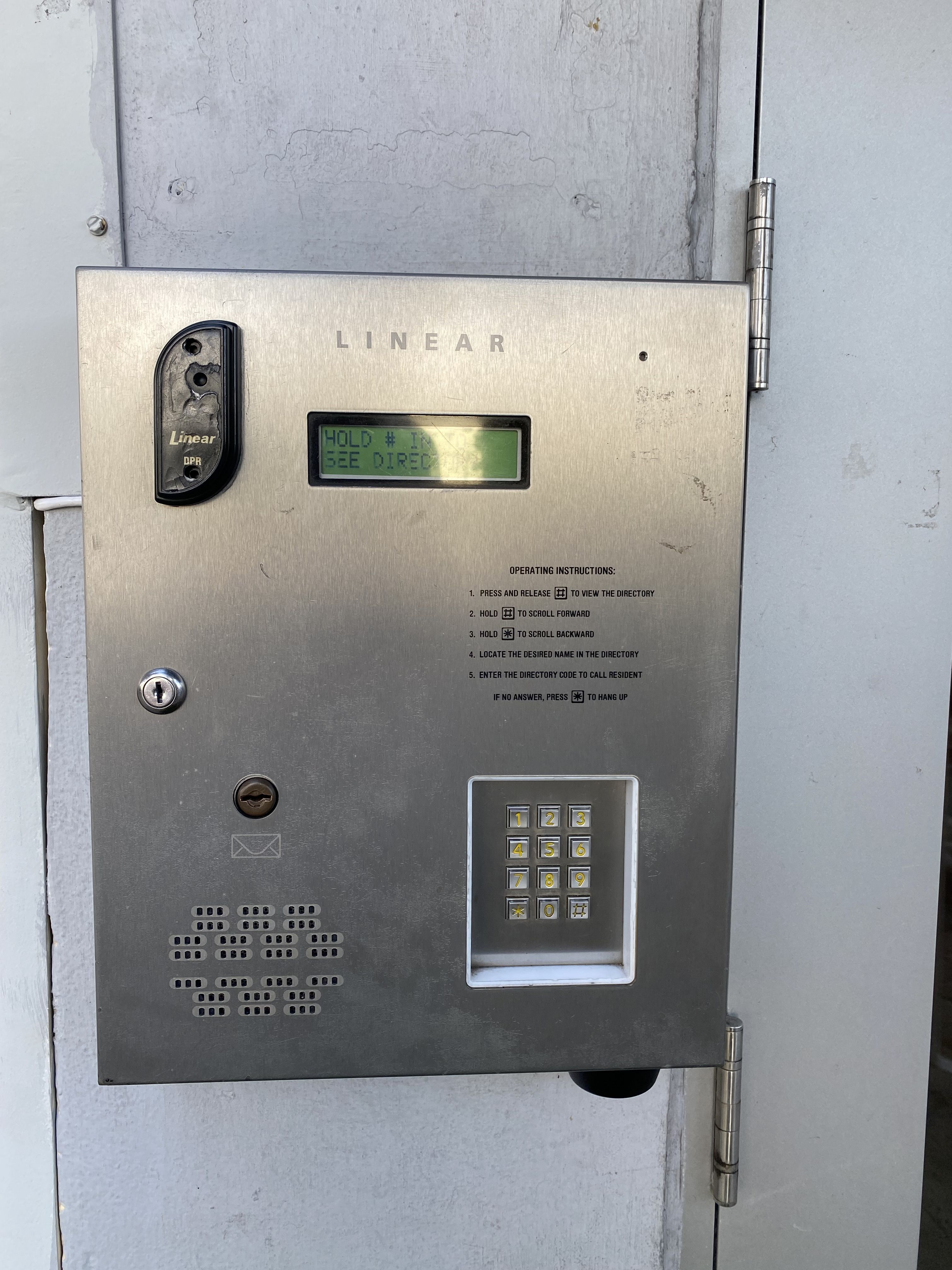 Picture of the keypad at our front door. It has a black receiver on the top left, a small screen just to the right of that, and a keypad on the bottom right. The whole keypad is made out of some stainless-steel looking metal.